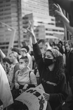 Close-up of hands joined in support and solidarity in an outdoor setting.