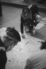 grayscale photo of woman in black jacket and black pants holding map