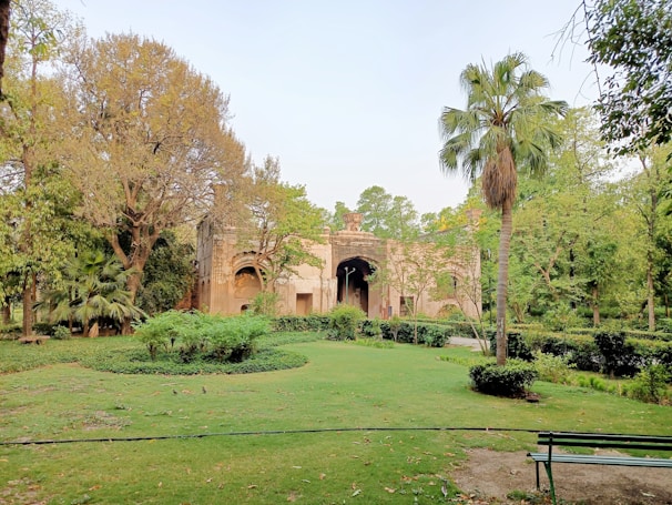 A serene view of a historical garden with lush greenery and a traditional structure.