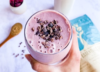 person holding cup of coffee with berries