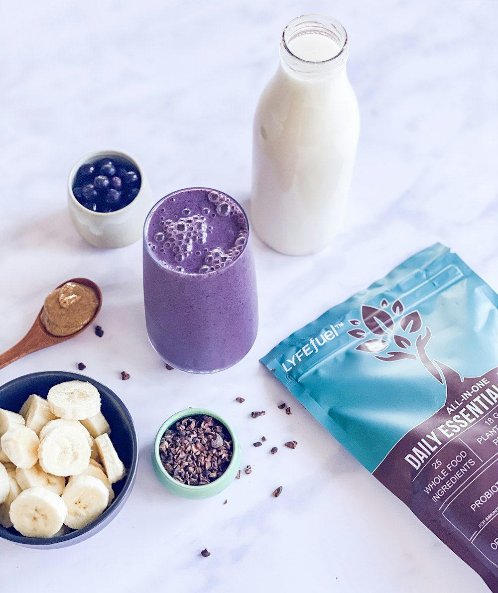 milk in clear glass bottle beside brown wooden spoon