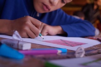 boy in blue shirt holding pen