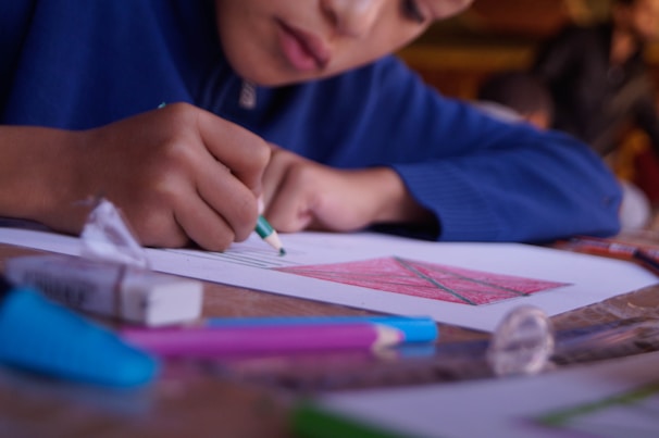 boy in blue shirt holding pen
