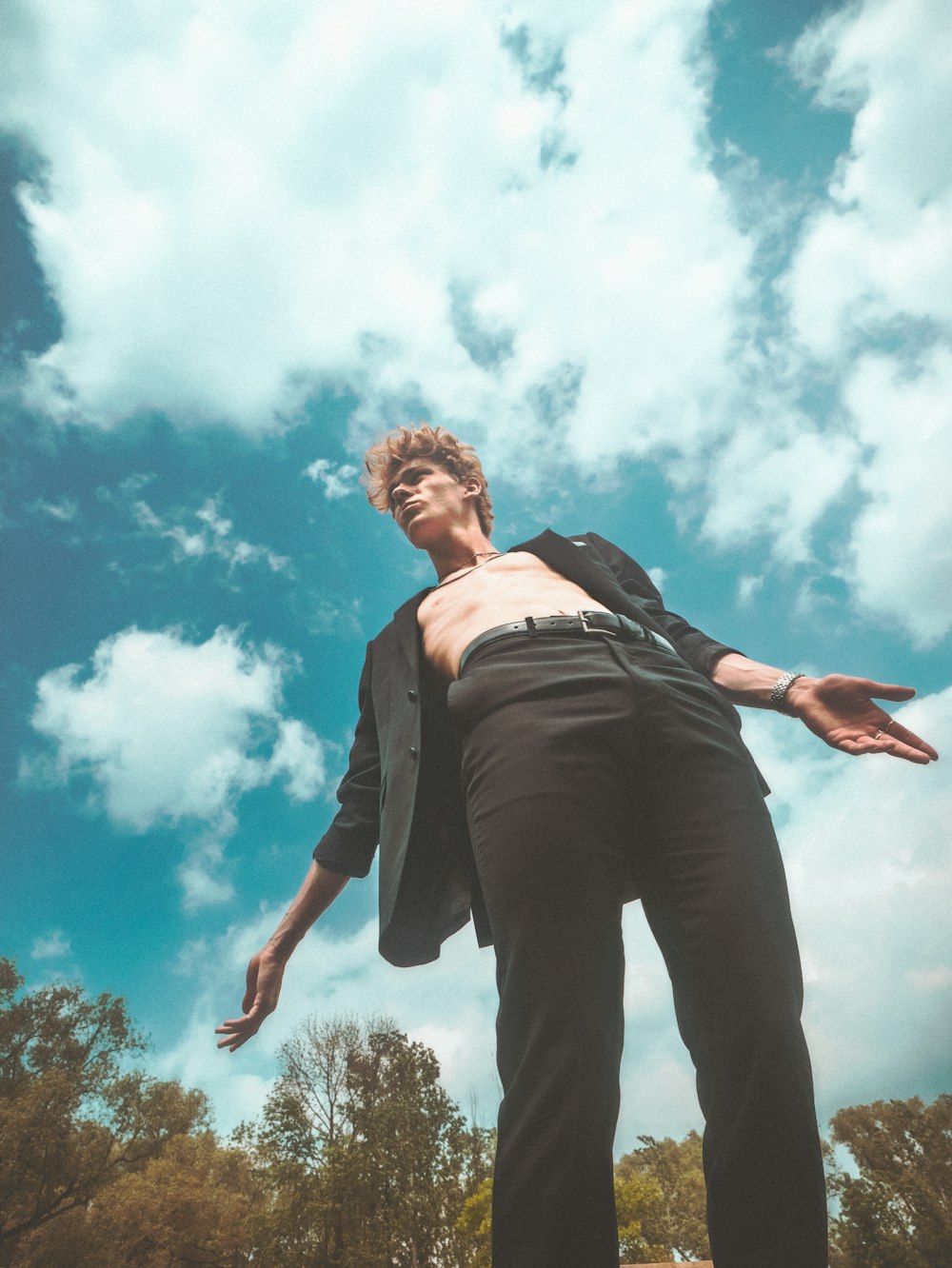 man in black suit jacket standing under blue sky during daytime