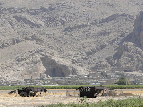 Traditional Berber tents nestled in the Atlas Mountains surrounded by rugged peaks.