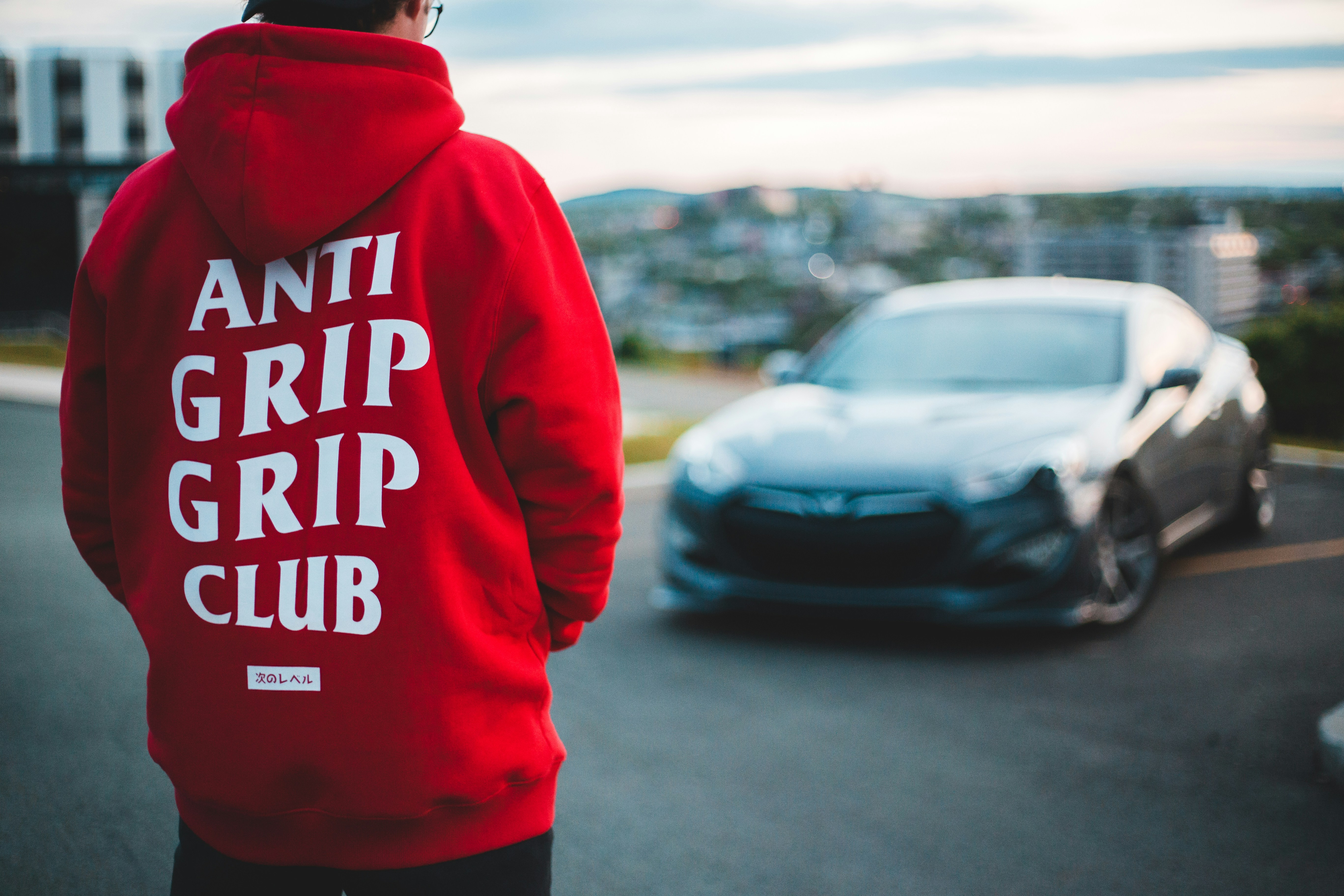 person in red and white hoodie standing on road during daytime