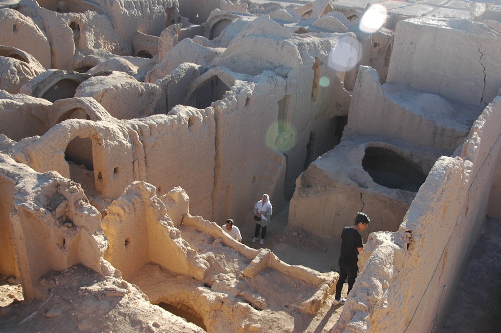 people climbing on brown rock formation during daytime