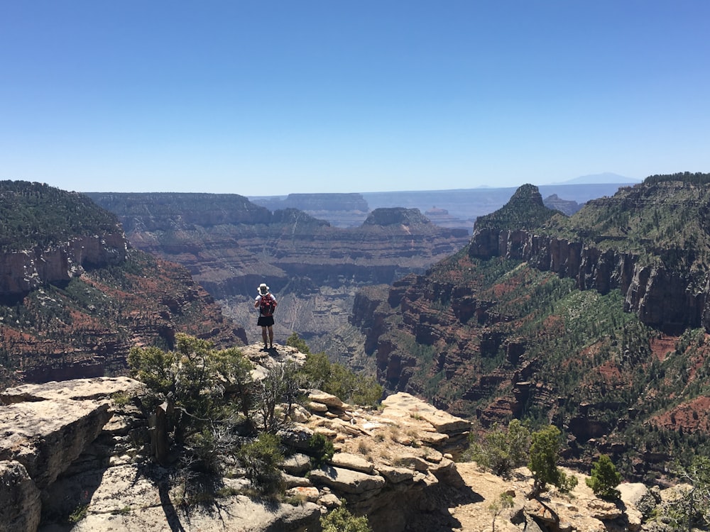 person standing on rocky mountain during daytime