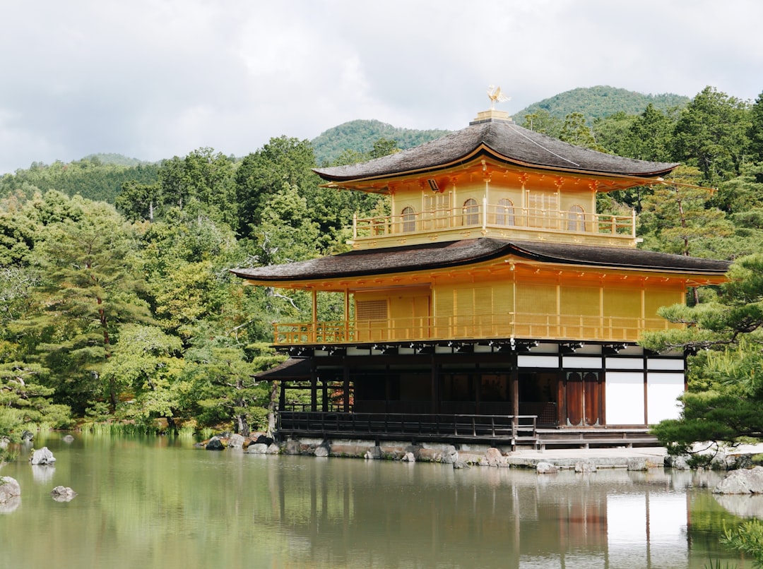 brown and black temple near green trees and lake during daytime