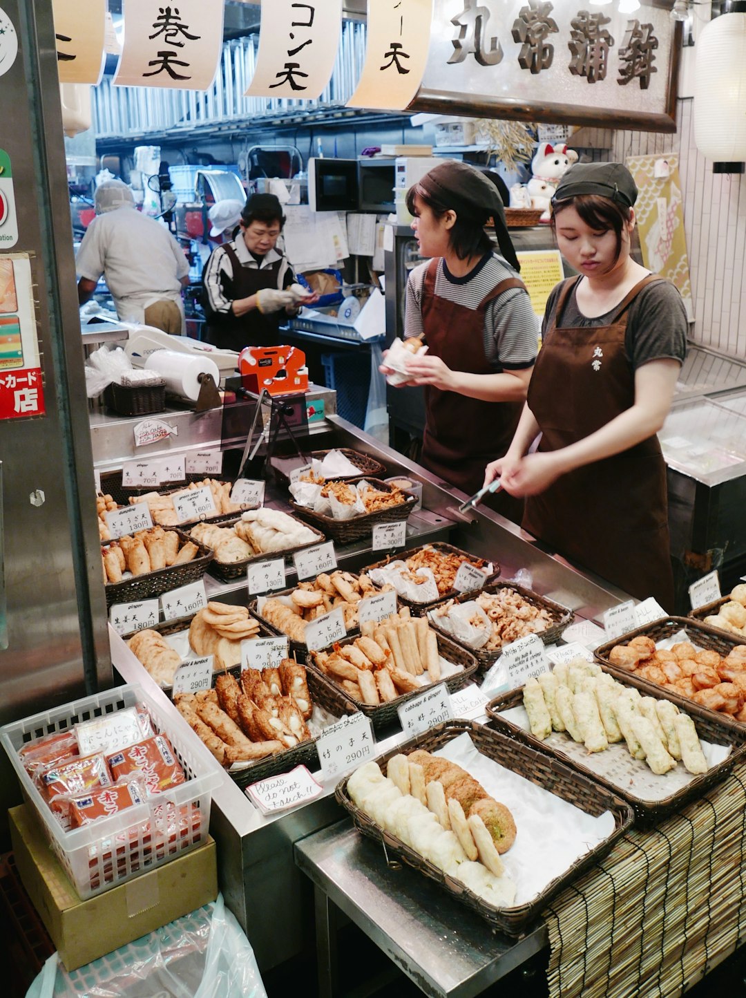 man in brown crew neck t-shirt standing in front of food stall