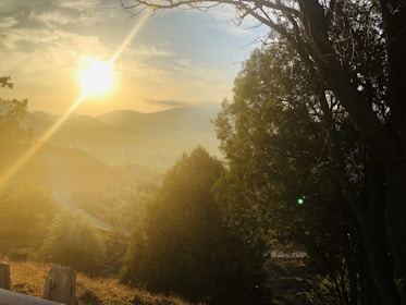 A serene sunset view from Mont Passot, with silhouettes of visitors admiring the sky's warm hues.