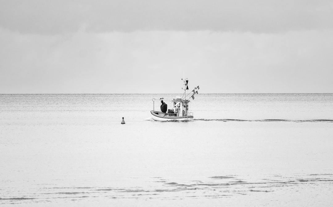 grayscale photo of 2 person riding on boat on sea