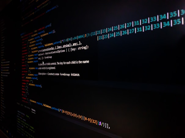 Lines of code are displayed on a computer screen, featuring syntax highlighting with different colors to distinguish functions, variables, and annotations. The image is somewhat dark, focusing on the brightly colored text on a black background.