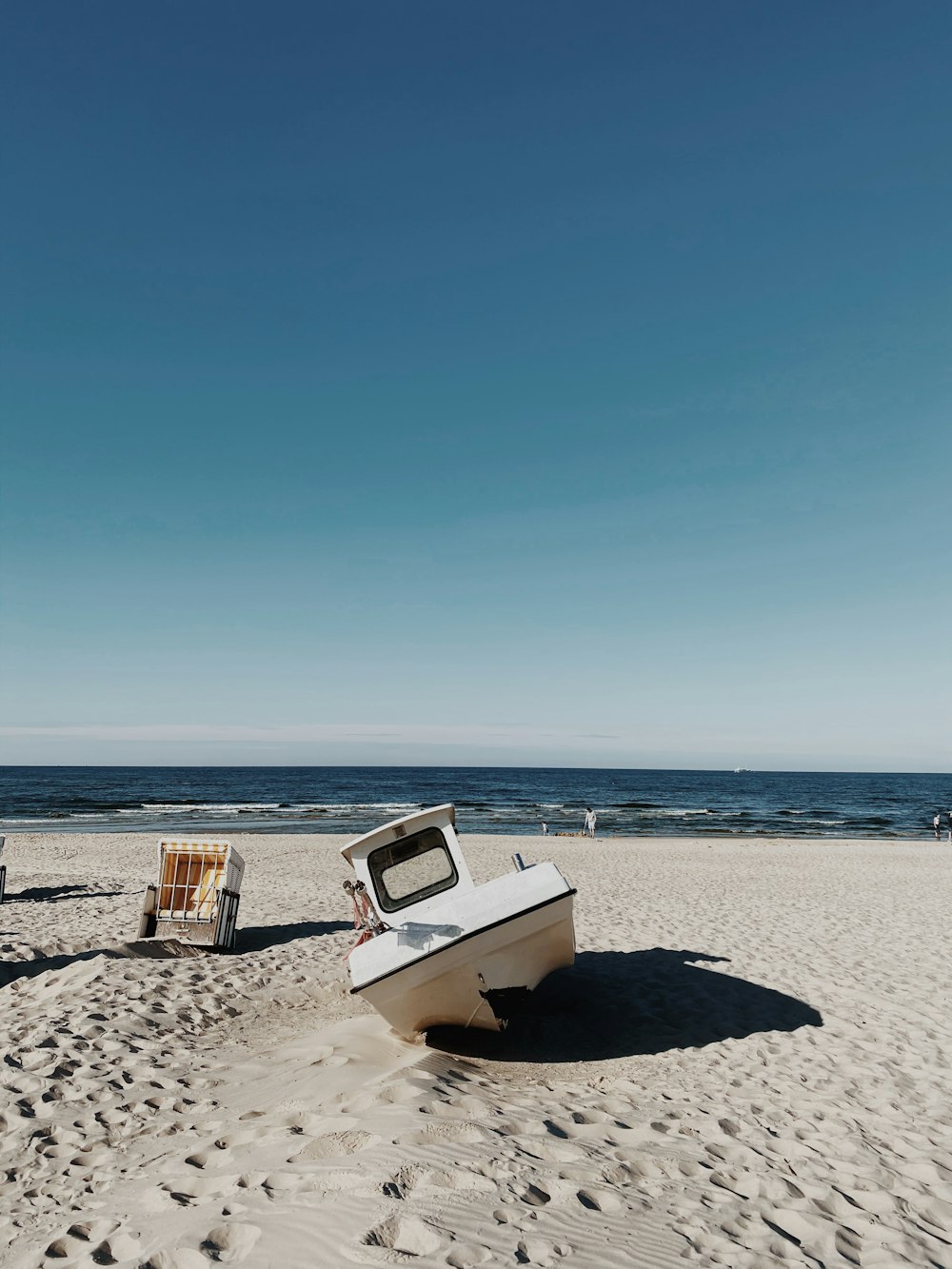 Barco blanco y marrón en la playa durante el día