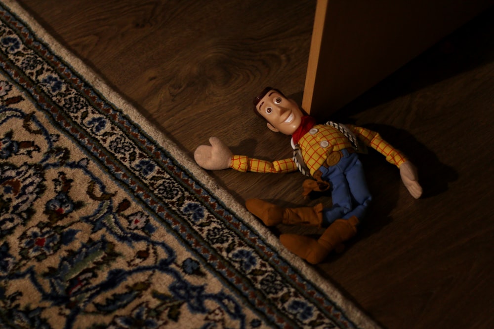 boy in blue and white plaid dress shirt and blue pants sitting on brown wooden floor