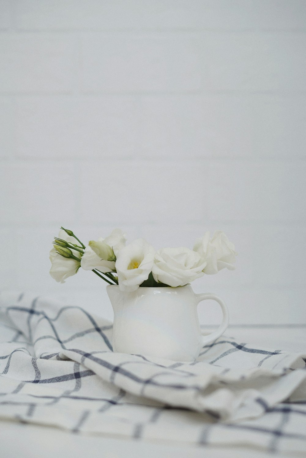 Weiße Blumen in weißer Keramikvase