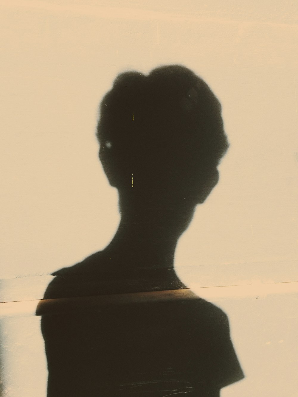 silhouette of woman in front of white wall