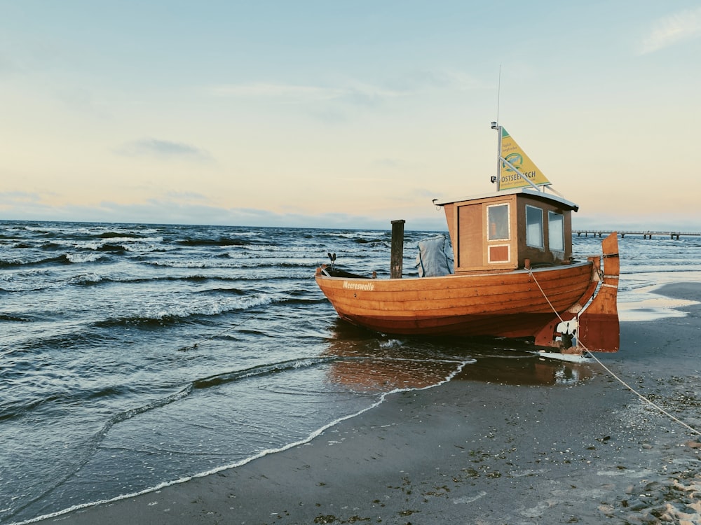 brown and white boat on sea shore during daytime