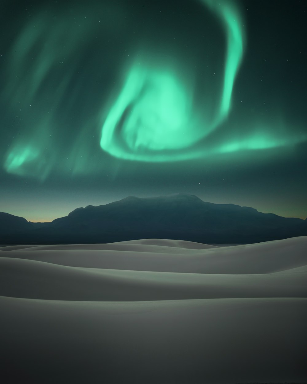 L'aurora boreale verde sopra la montagna