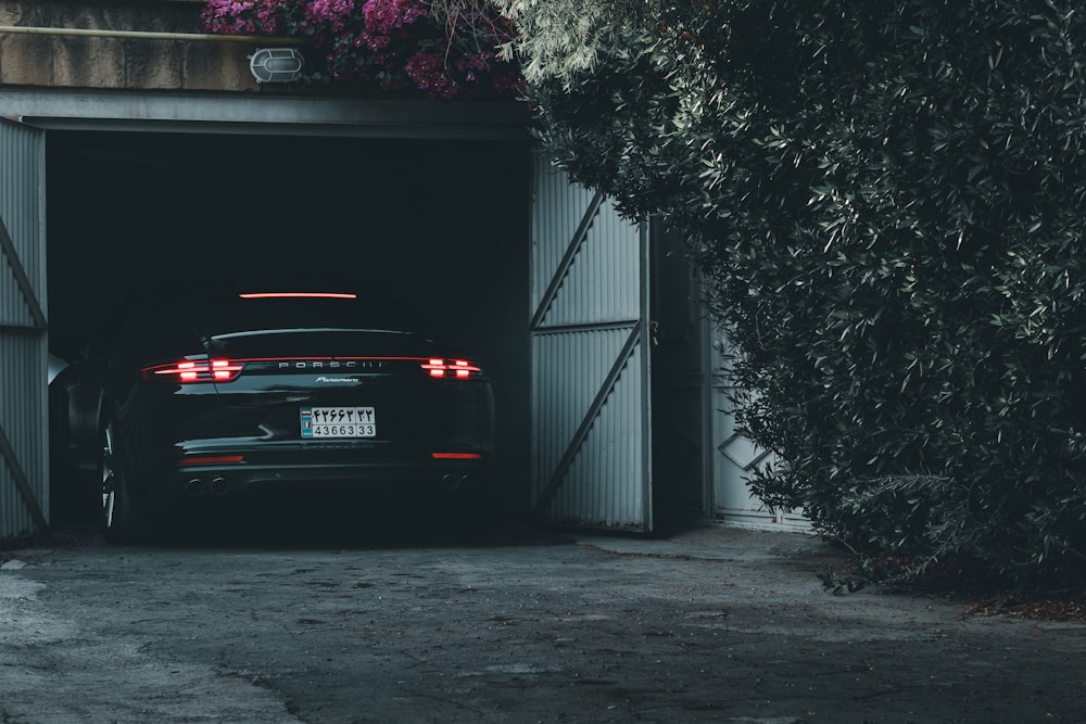 black car parked beside black metal gate