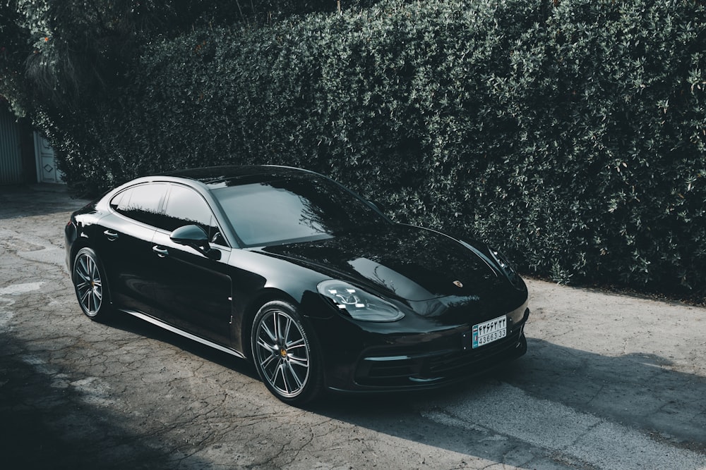 Porsche 911 negro aparcado sobre pavimento gris