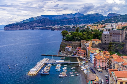 aerial view of city buildings near body of water during daytime in Sorrento Italy