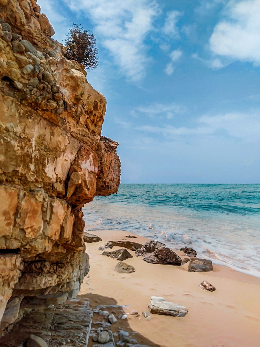 brown rock formation near body of water during daytime