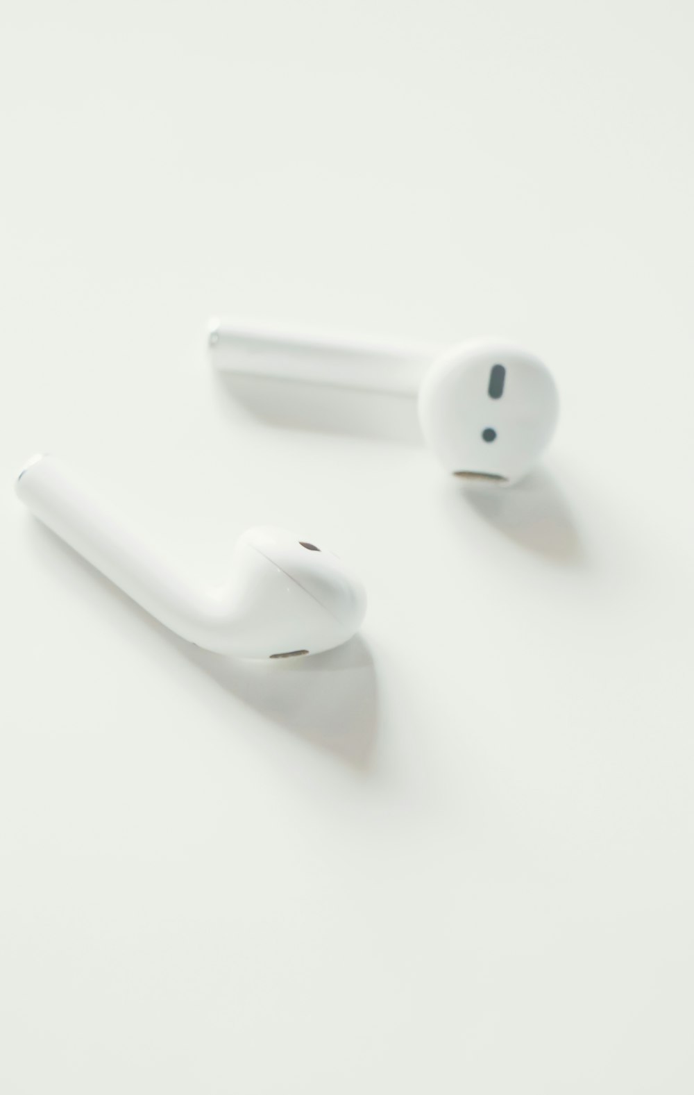 white apple earpods on white surface