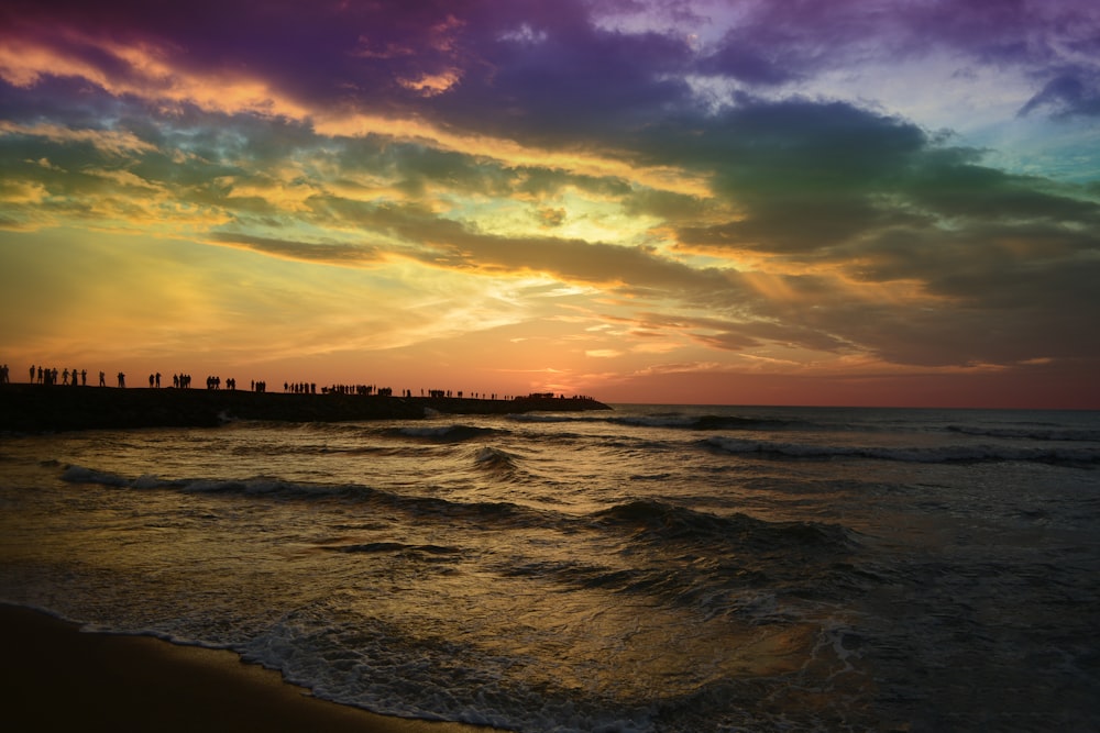 body of water under cloudy sky during sunset