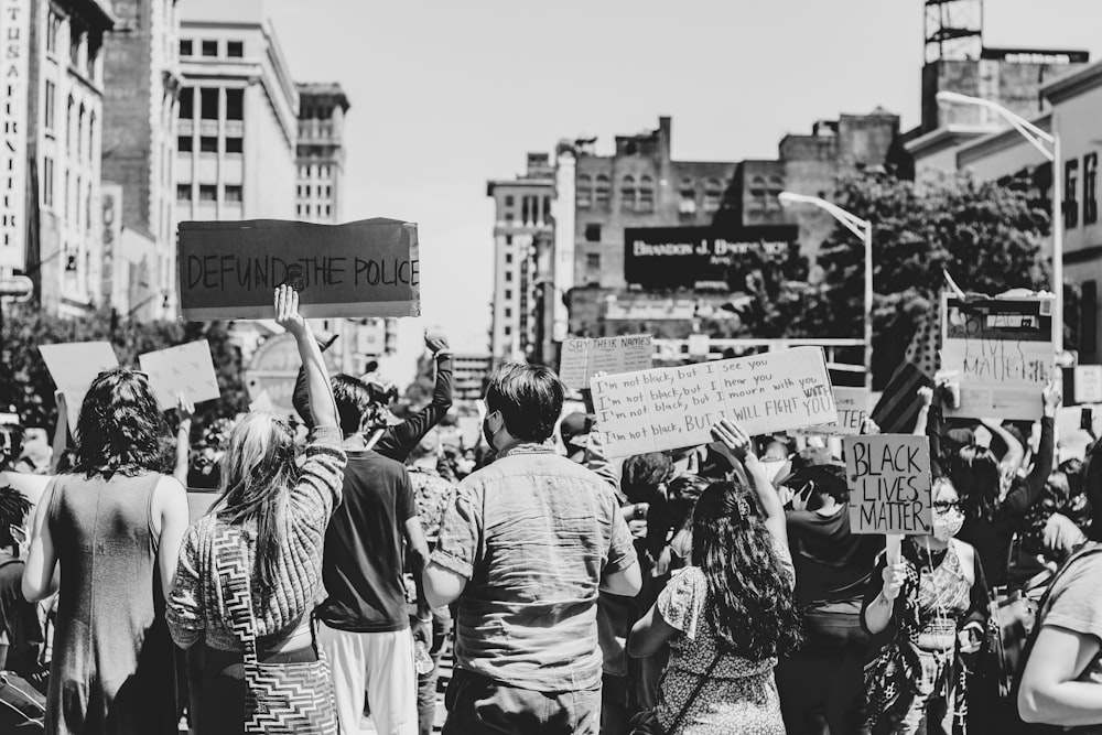 grayscale photo of people holding a banner