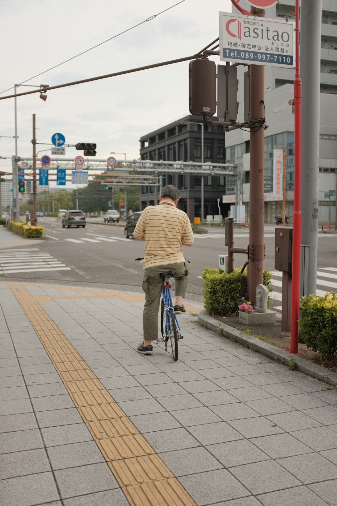 man in yellow jacket riding bicycle on road during daytime