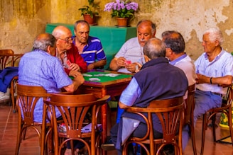 group of men sitting on chair in front of table