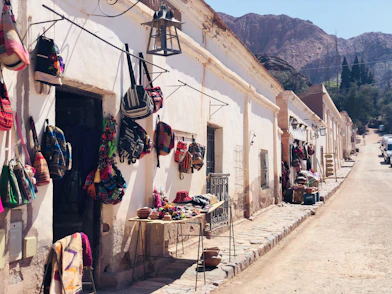 assorted clothes hanged on clothes line near houses and mountain during daytime