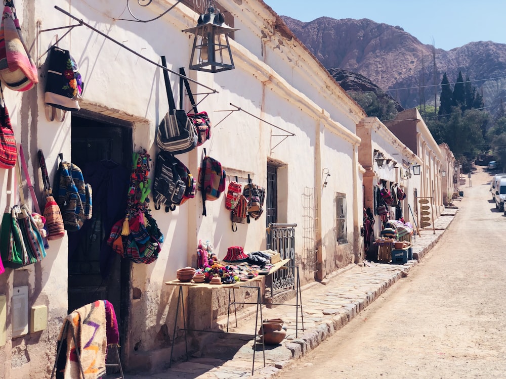 assorted clothes hanged on clothes line near houses and mountain during daytime