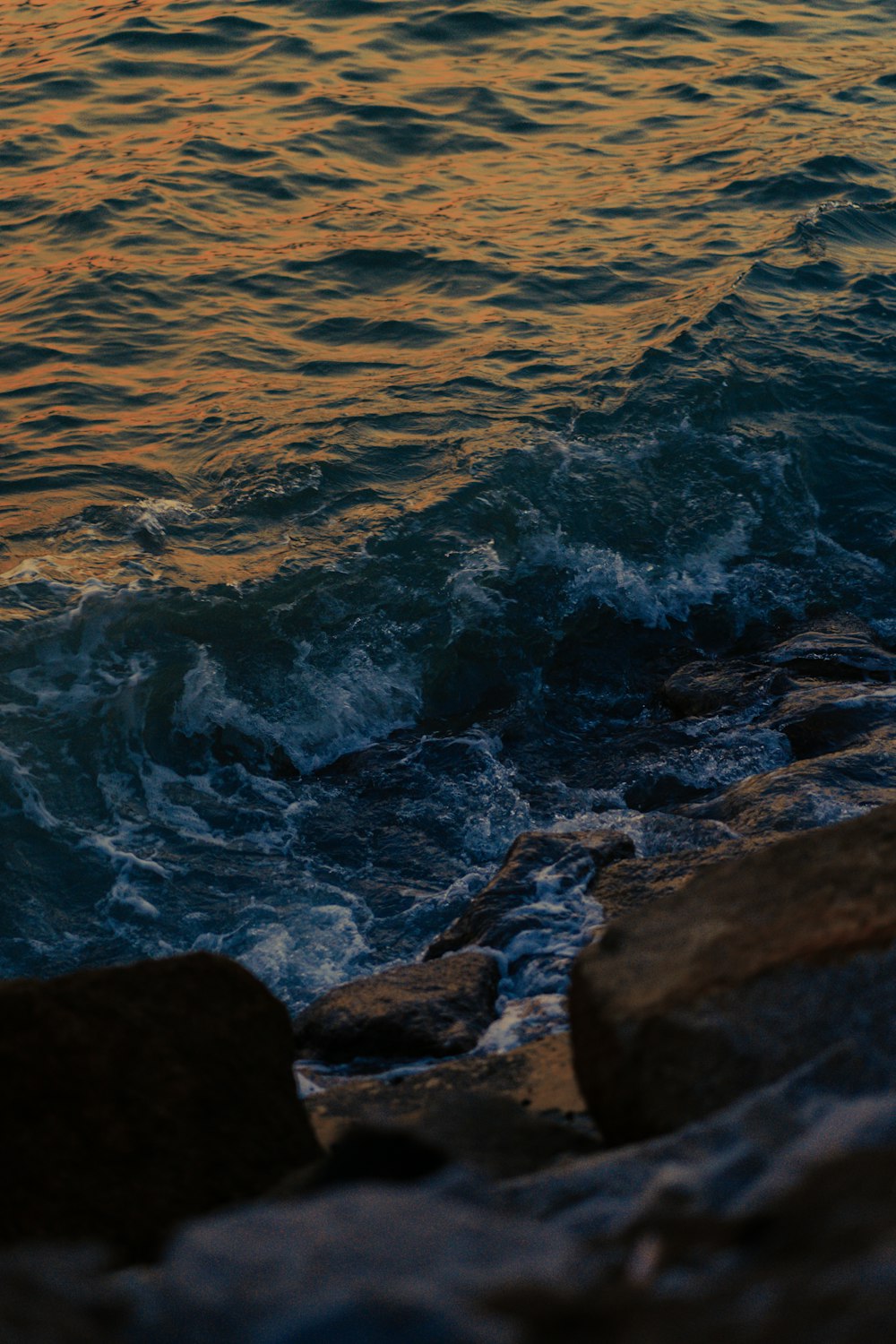 water waves hitting rocks during daytime