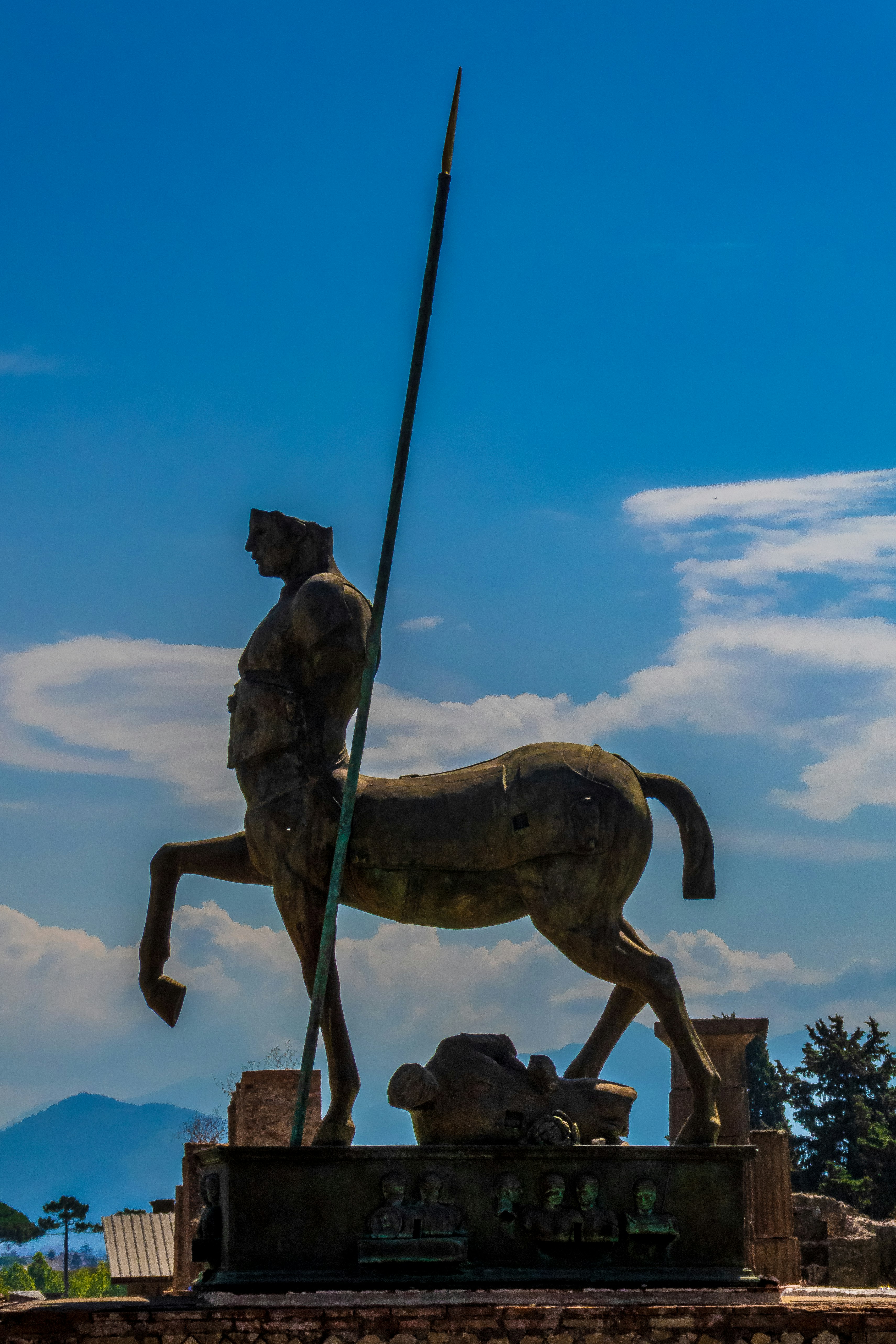 A modern day statue, made to look historic at Pompeii, Italy, with Mount Vesuvius in the background.