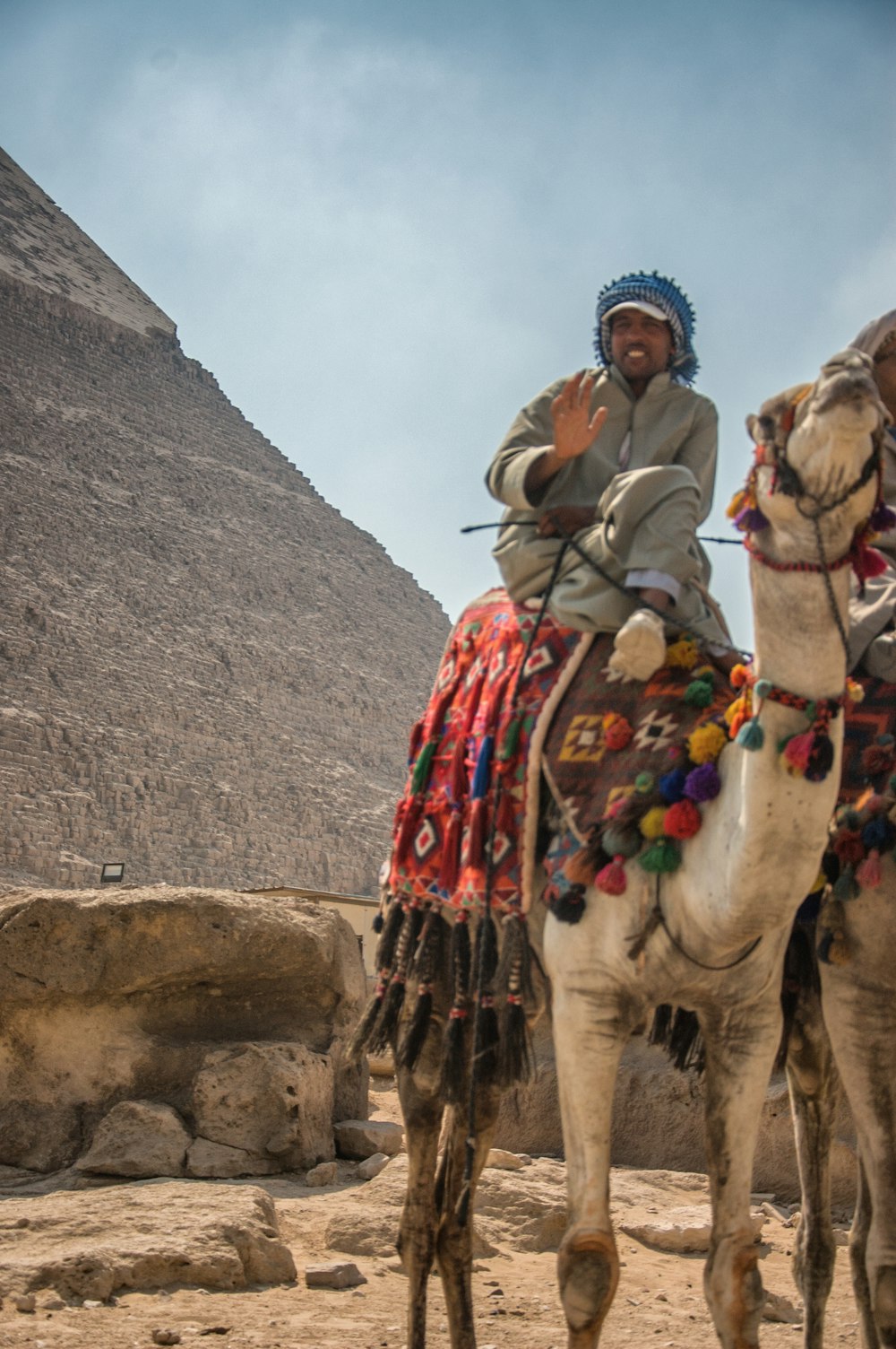 man riding camel on mountain during daytime