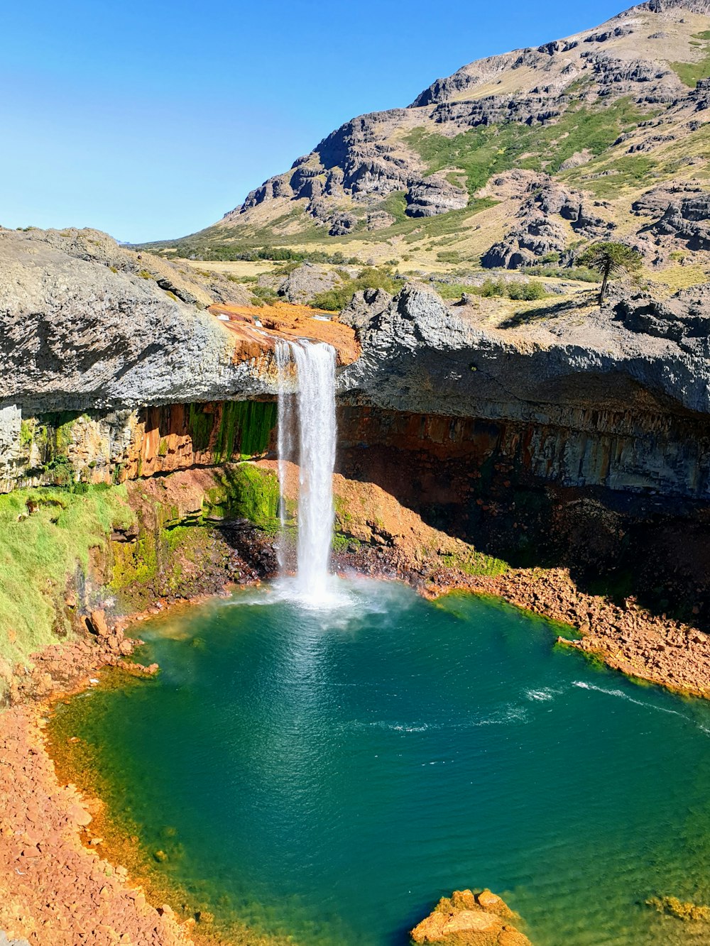 waterfalls on brown rocky mountain during daytime
