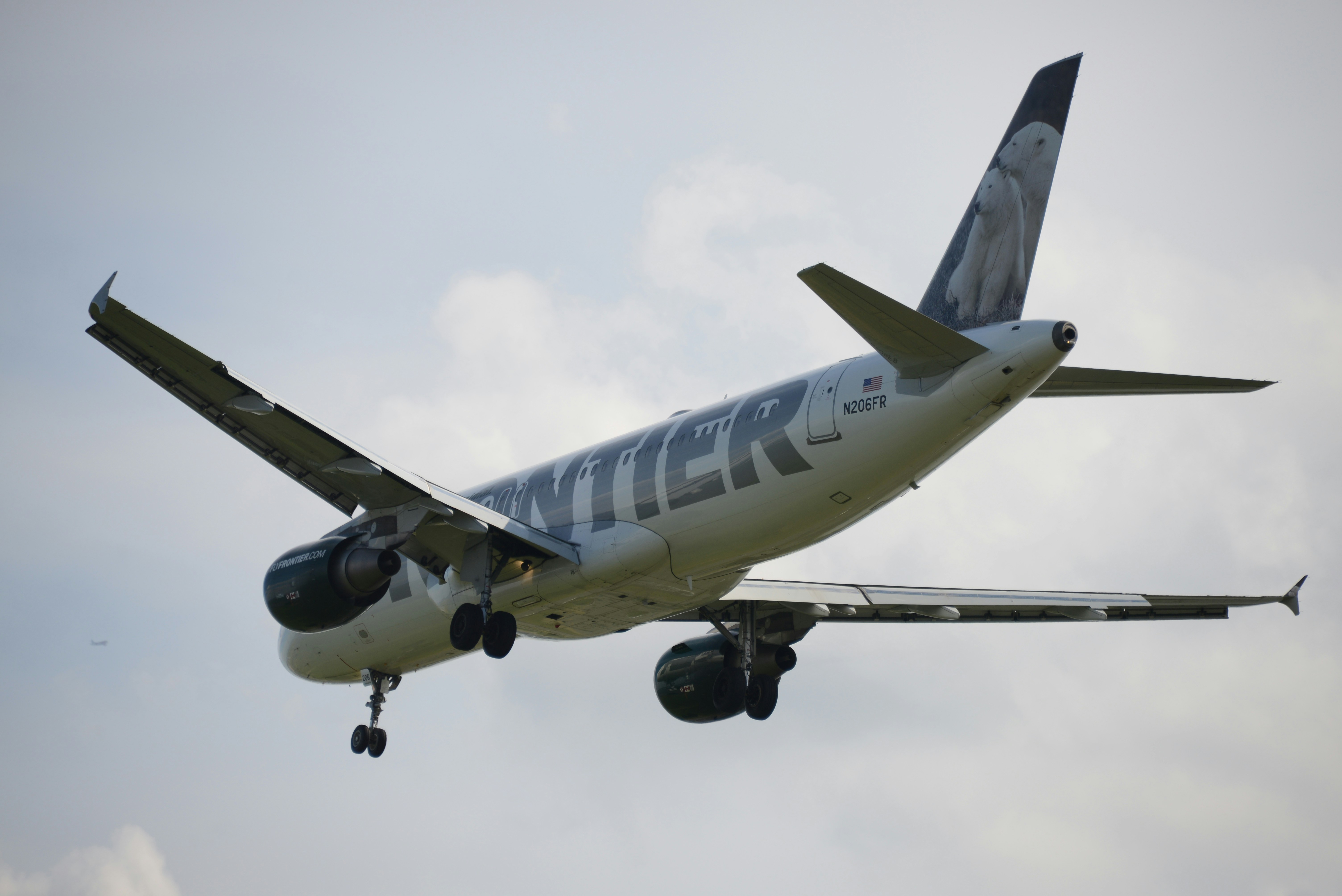 weißes und blaues Flugzeug tagsüber unter weißen Wolken