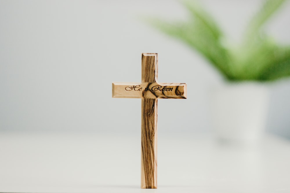 緑の葉と茶色の木製の十字架