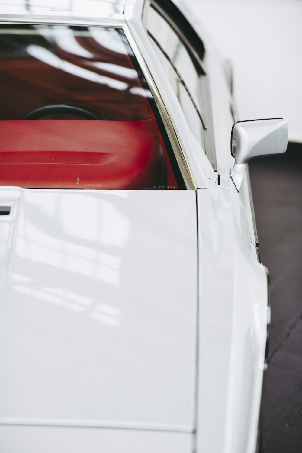 white and red car in a parking lot during daytime