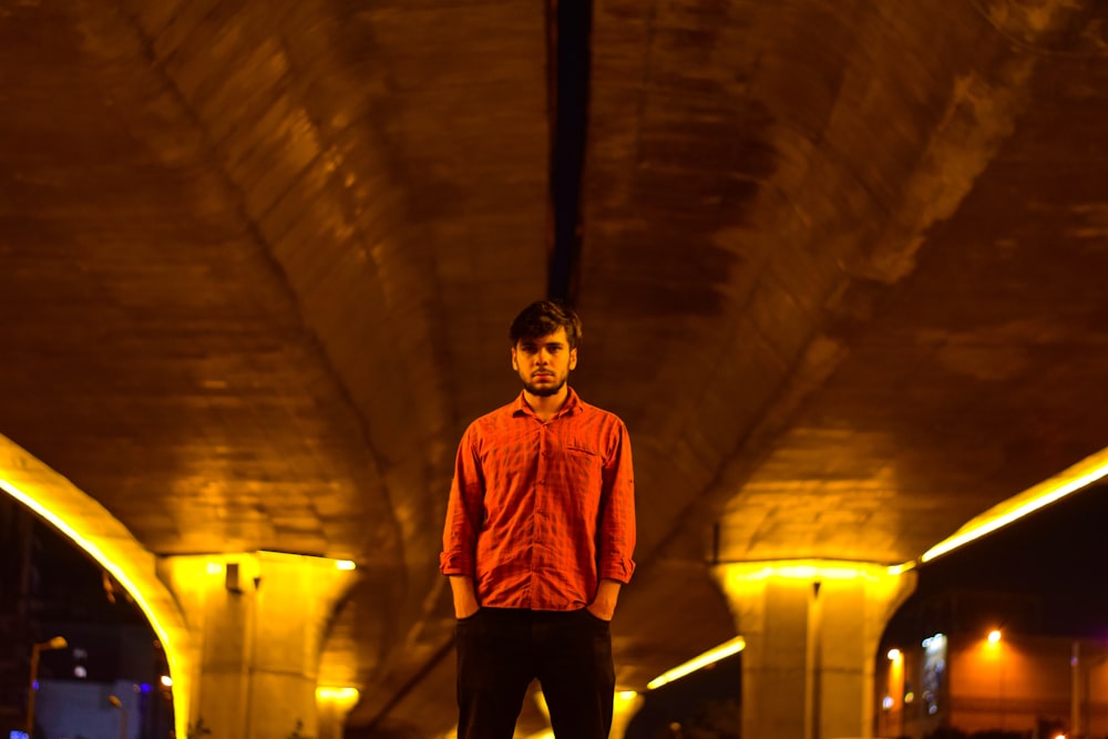 빨간 드레스 셔츠와 검은 바지를 입은 남자가 터널에 서 있다