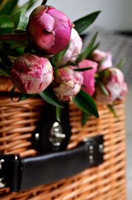 Soft pastel artificial peonies arranged in a vintage basket.