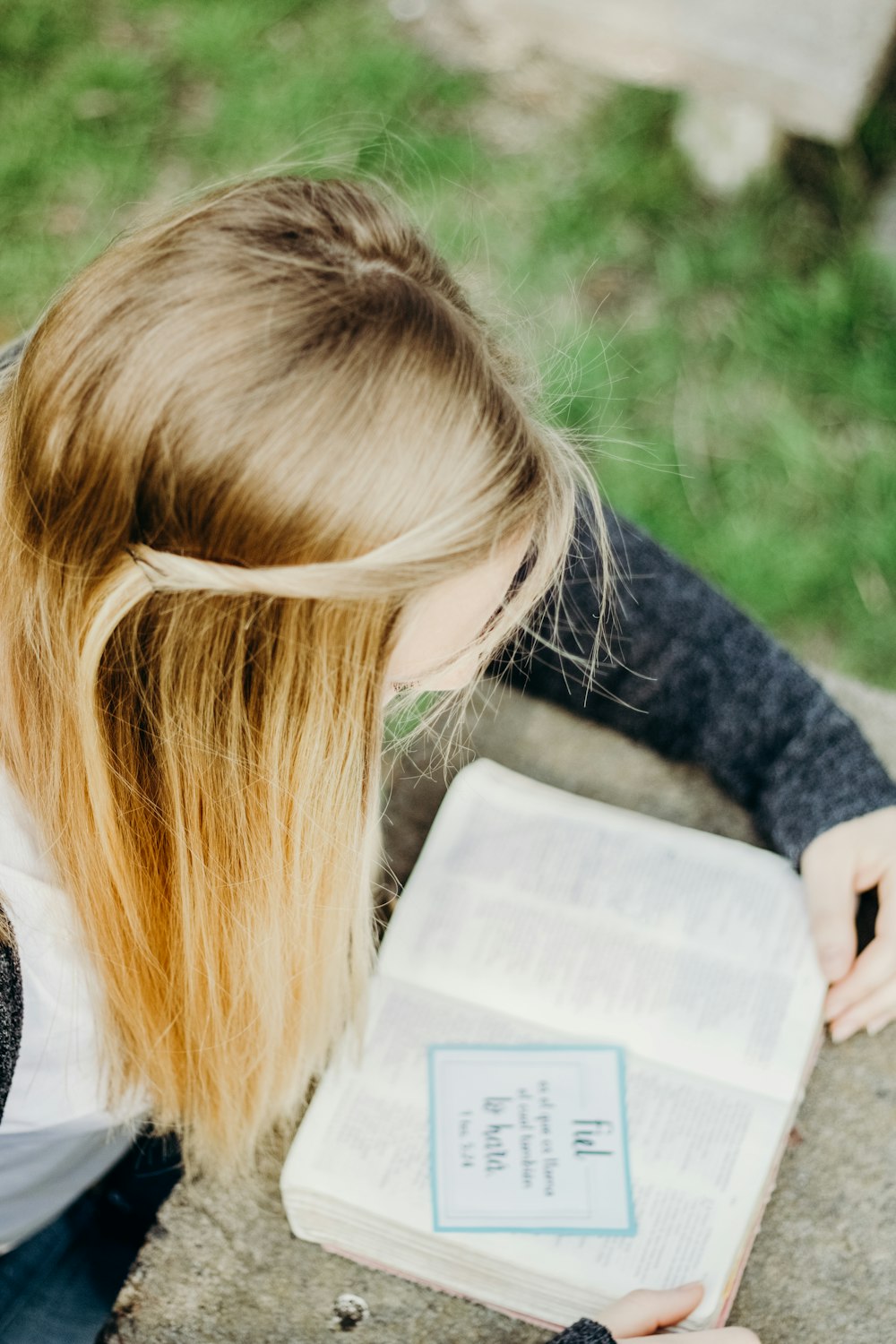 woman in black sweater reading book