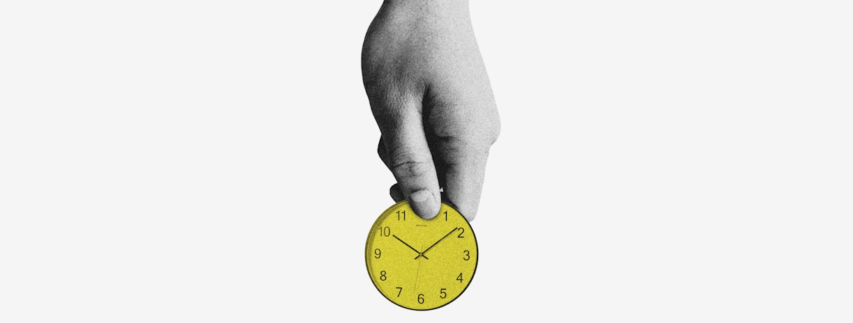person holding yellow round analog clock