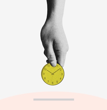 person holding yellow round analog clock