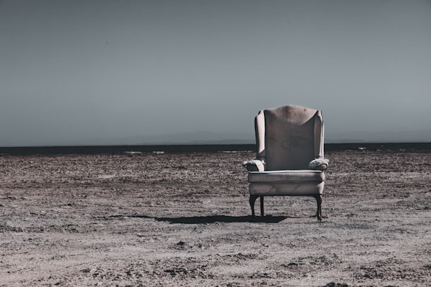 Neutral emmpty armchair on brown sand during daytime
