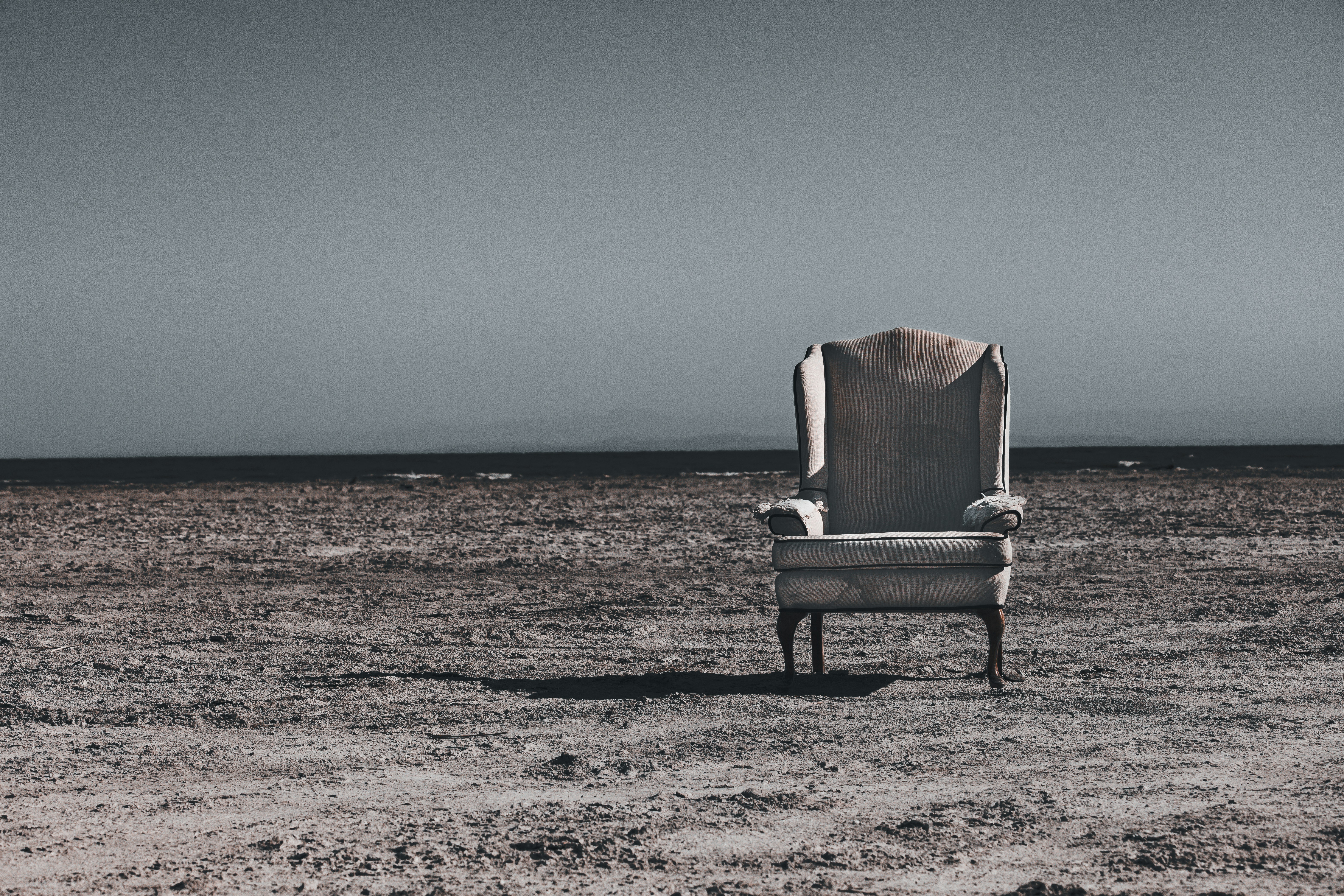 Lone vintage armchair on the beach along the Salton Sea, Late afternoon in Southern California.
