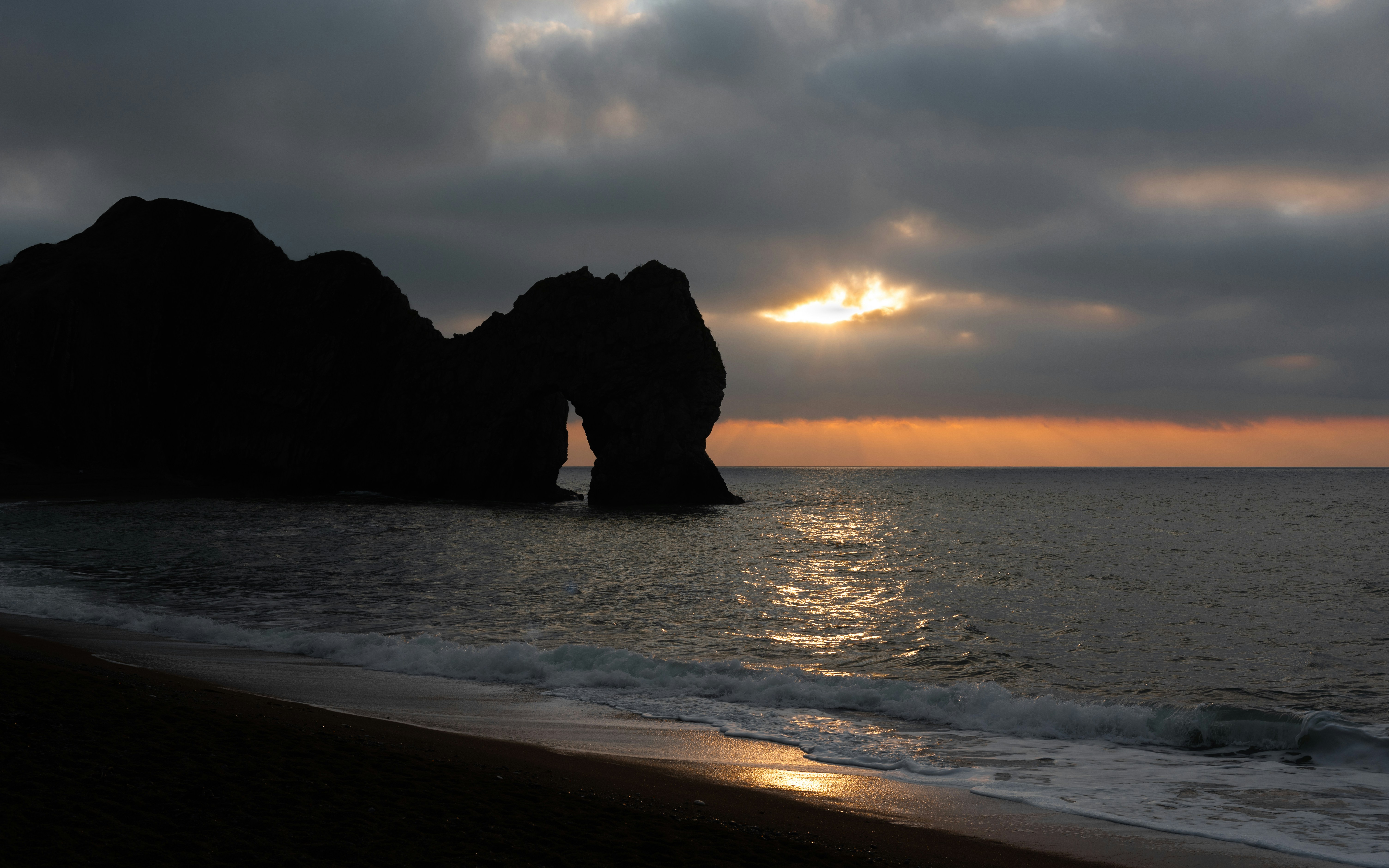 rock formation on sea during sunset