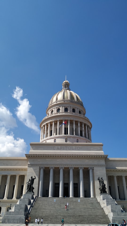 white concrete dome building under blue sky during daytime in National Capital Building Cuba